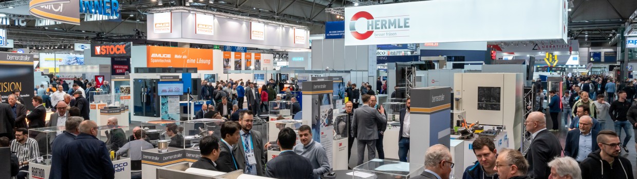 Menschen stehen an Messeständen und schauen sich die Produkte an und unterhalten sich, Messeimpressionen Intec - Internationale Fachmesse für Werkzeugmaschinen, Fertigungs- und Automatisierungstechnik